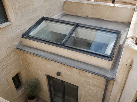 Illustrative glazed skylight over a small limestone courtyard with aluminium frame joins.